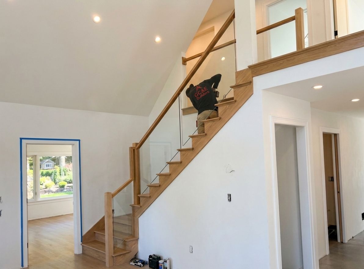 GC&E Builders crew member installing interior staircase finishings